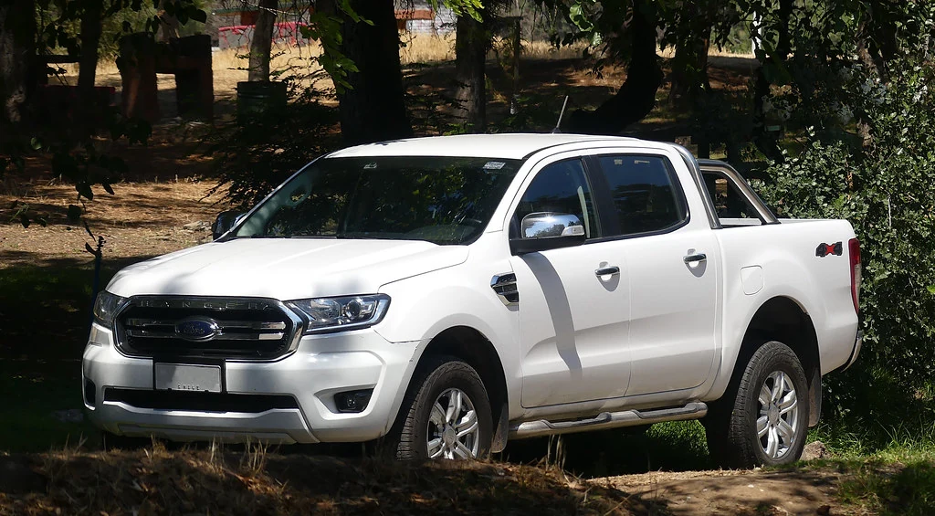 Ford Ranger XLT 2020 blanca, vista frontal de tres cuartos en un entorno arbolado